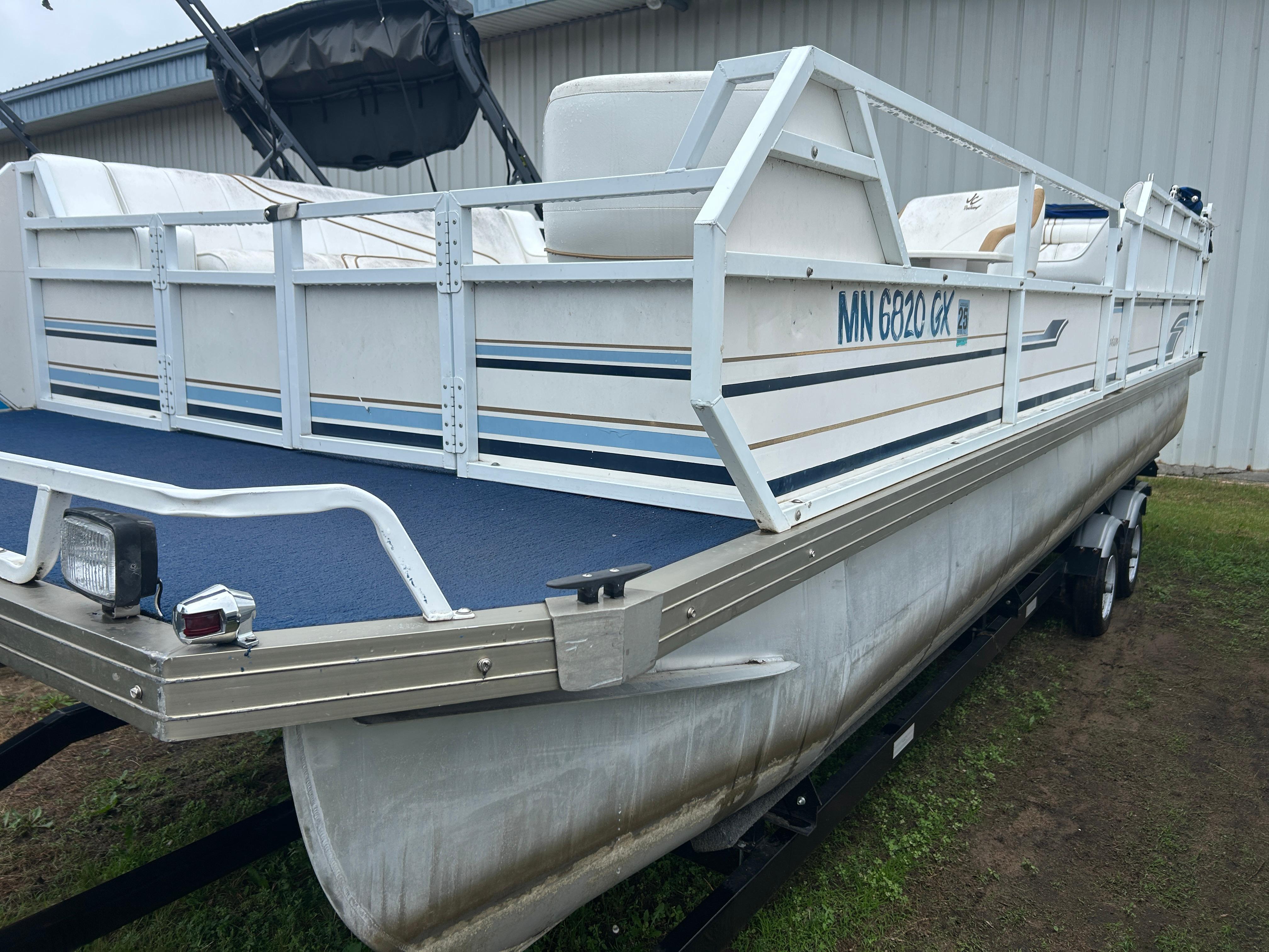 JC Suntoon 24 1996 JC Suntoon 24 pontoon boat on trailer, white with blue accents, parked outdoors.