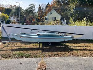 Hobie Cat 16 1989 Hobie Cat 16 sailboat on trailer, parked in front of a white fence.
