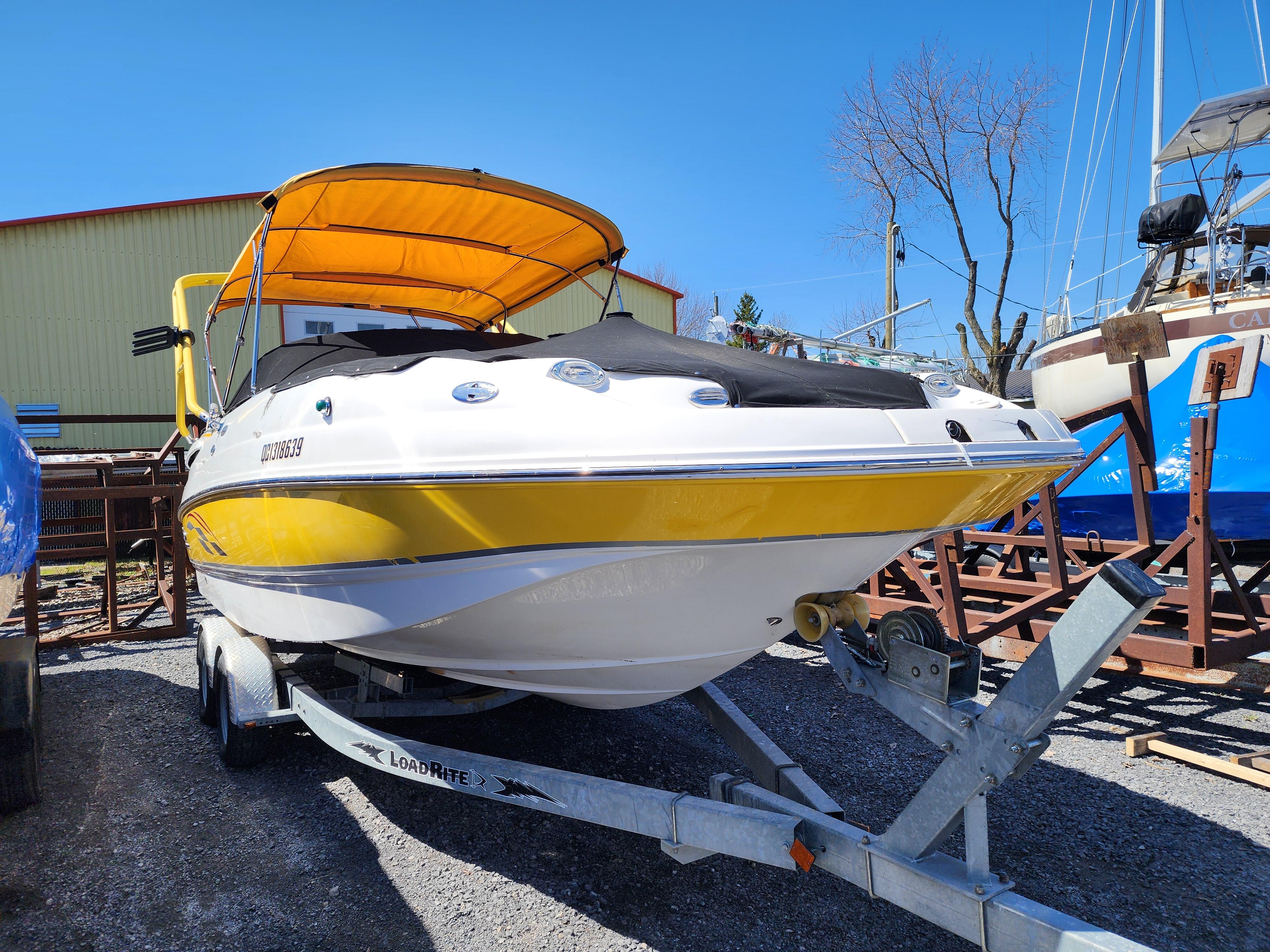 Chaparral 236 Sunesta 2005 Chaparral 236 Sunesta boat with yellow accents on a trailer, under a clear blue sky.
