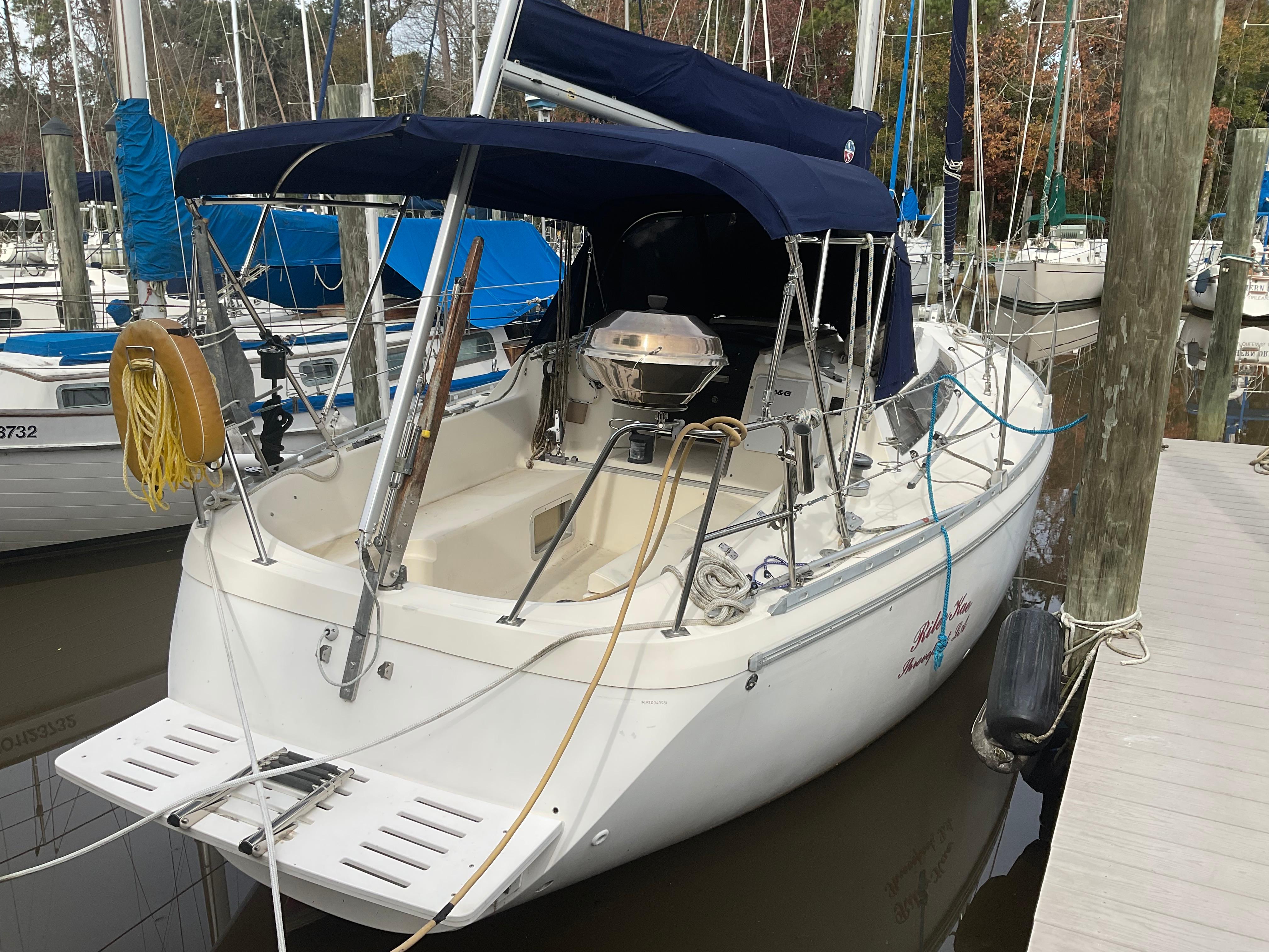 Jeanneau Attalia 1983 Jeanneau Attalia sailboat docked, featuring a blue canopy and white hull.