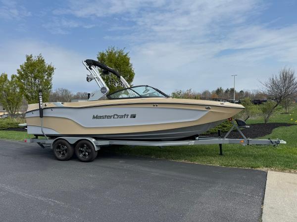 MasterCraft XT24 2024 MasterCraft XT24 boat on trailer, parked outdoors on a sunny day.