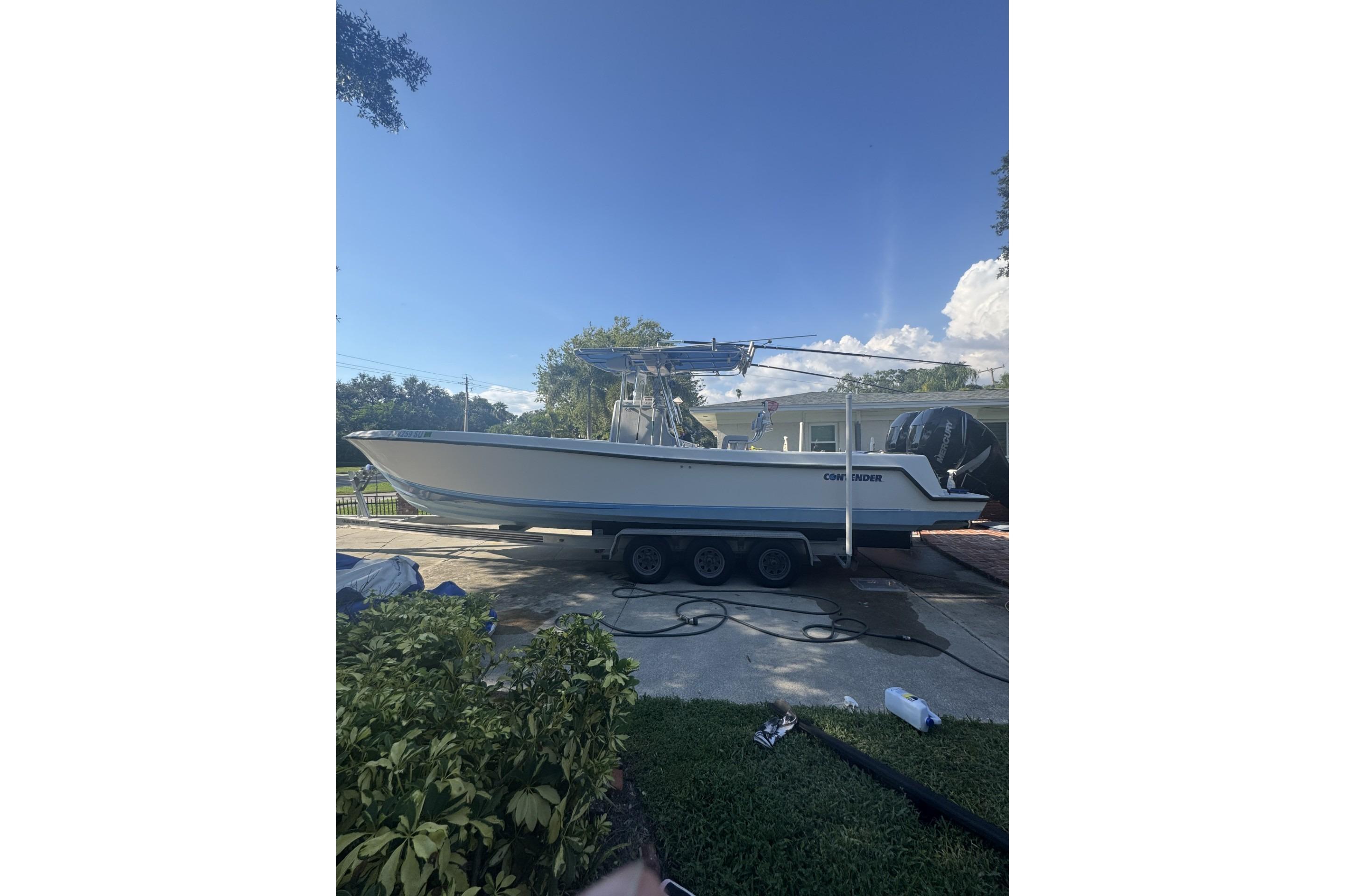 Contender 31 Open 2005 Contender 31 Open boat on trailer, parked outdoors under clear blue sky.