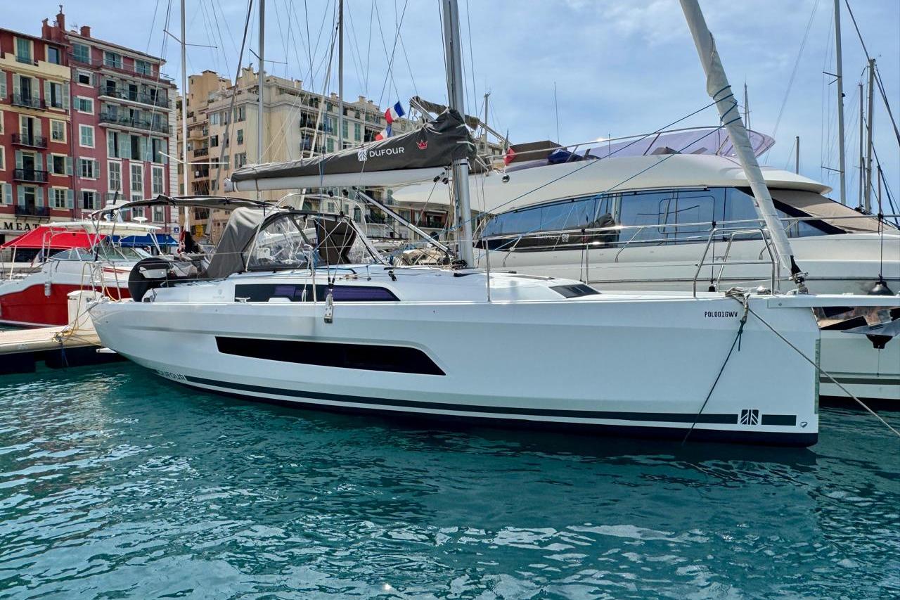 Dufour 37 2025 Dufour 37 yacht docked in a marina, surrounded by other boats.