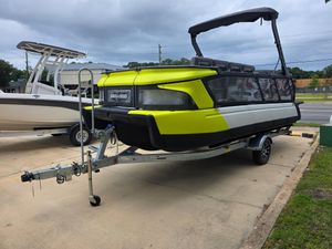 Sea-Doo Sport Boats Switch 2024 Sea-Doo Switch boat on trailer, vibrant yellow and black design, parked outdoors.
