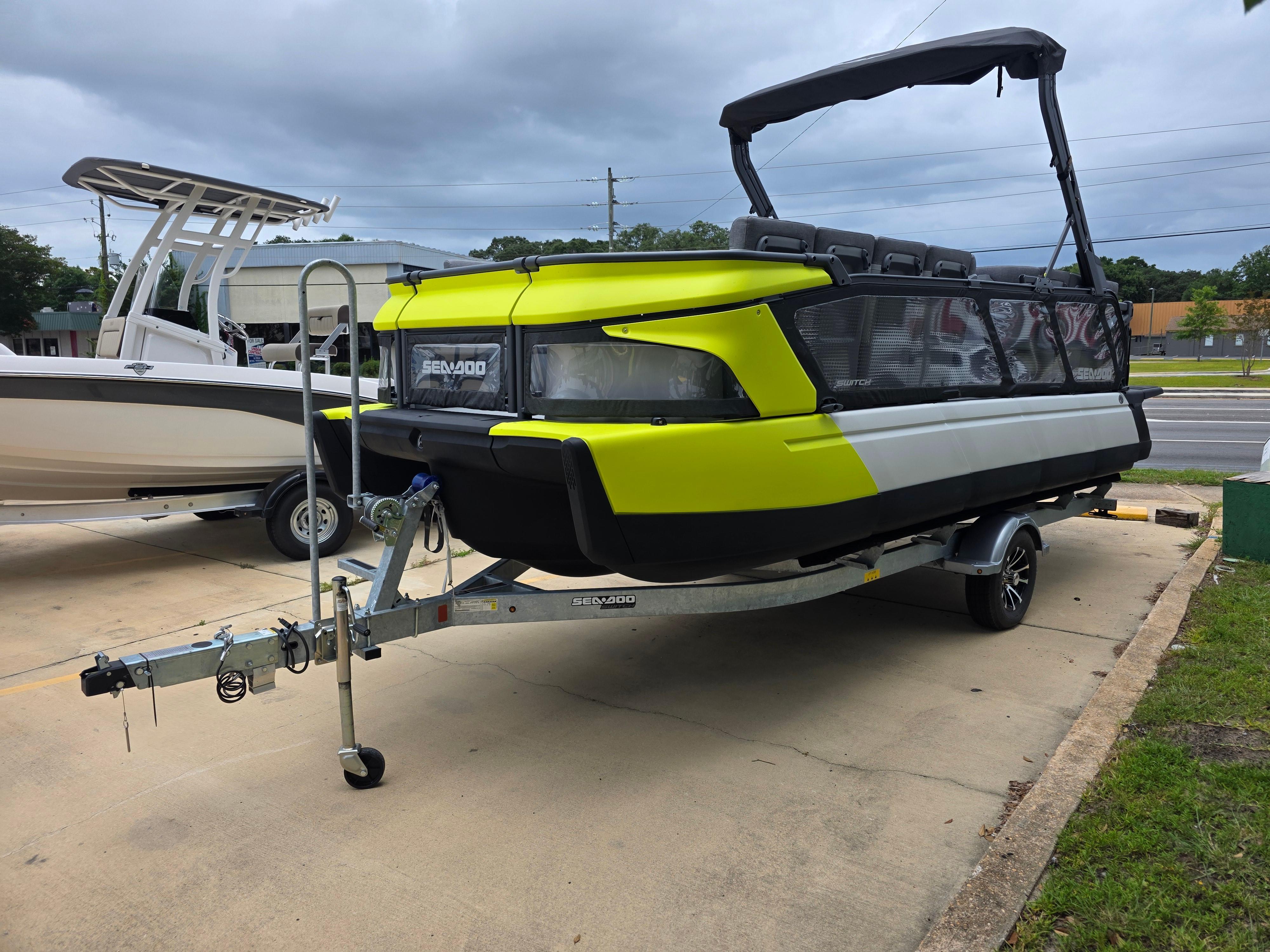 Sea-Doo Sport Boats Switch 2024 Sea-Doo Switch boat on trailer, vibrant yellow and black design, parked outdoors.