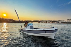 Aspen T13C 2026 Aspen T13C boat on water at sunset with bridge in background.