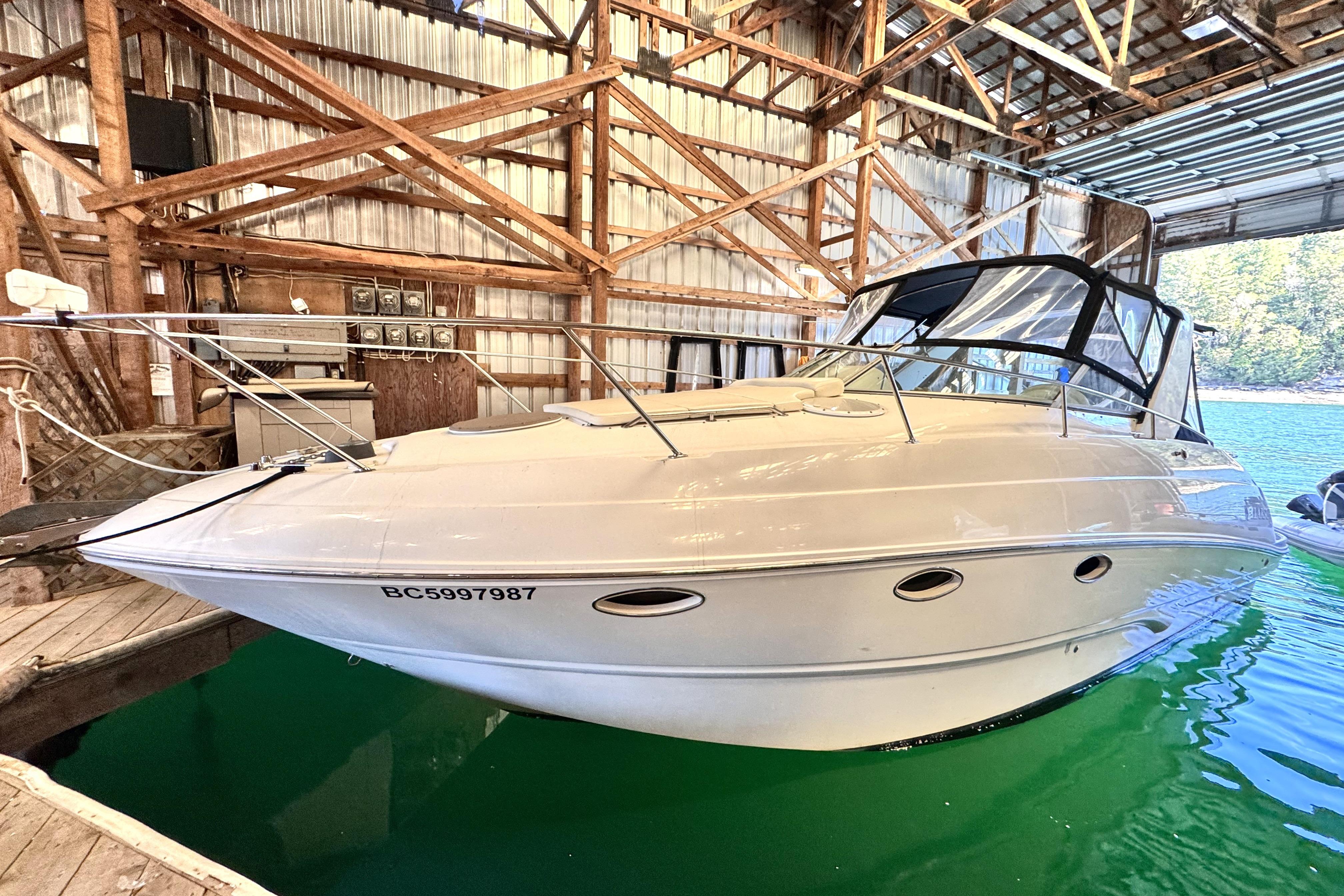 Larson Cabrio 310 2002 Larson Cabrio 310 boat docked in a wooden boathouse.