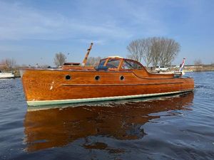 Rapsody 29 Classic 2002 Rapsody 29 wooden boat on calm water, clear sky background.