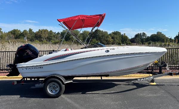 Tahoe T18 2024 Tahoe T18 boat with red canopy on trailer, parked outdoors.