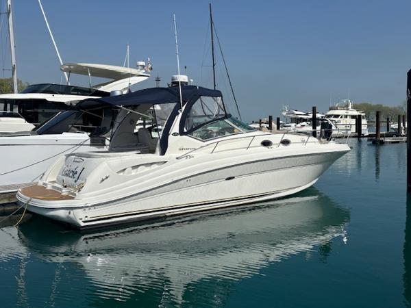 Sea Ray 340 Sundancer 2003 Sea Ray 340 Sundancer yacht docked in a marina, reflecting on calm water.