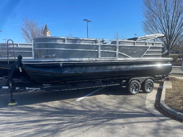 Ranger Reata 223C 2024 Ranger Reata 223C pontoon boat on trailer in parking lot.