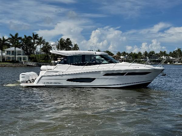 Regal 38 XO 2024 Regal 38 XO yacht cruising on a sunny day with palm trees in the background.