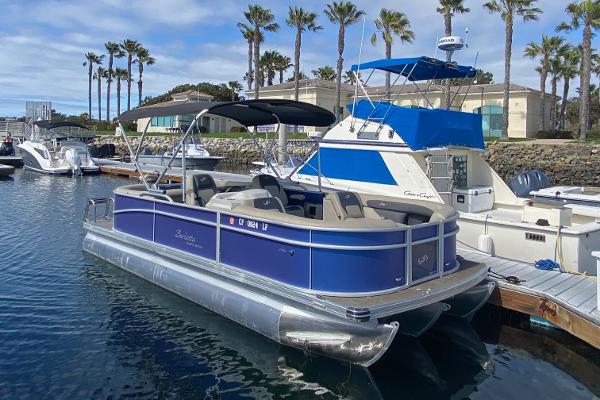 Barletta ARIA 22QC 2023 Barletta ARIA 22QC pontoon boat docked in marina, surrounded by palm trees.