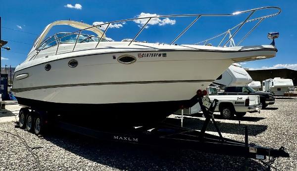 Maxum 3300 SCR 2002 Custom 33SCR boat on a trailer in a parking lot.