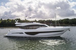 Princess S78 Luxurious 2021 Princess S78 yacht cruising on a serene waterway under a cloudy sky.
