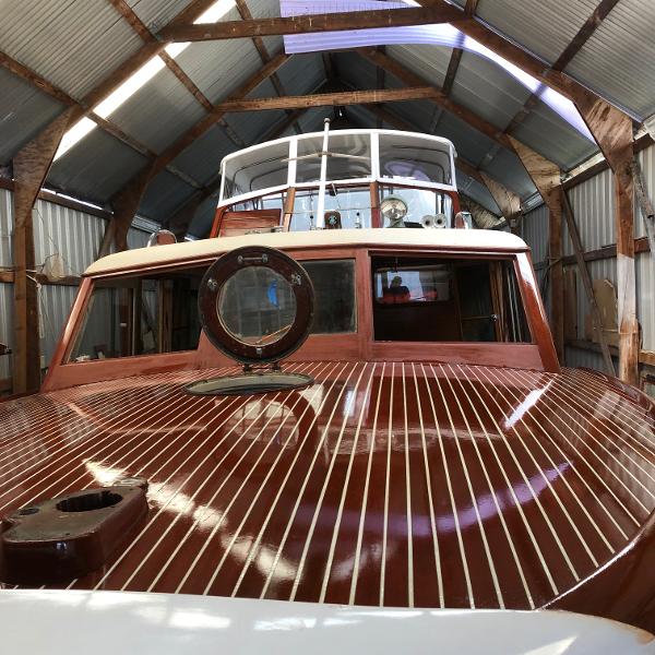 Chris-Craft DCFB 1954 Chris-Craft DCFB boat with wooden deck in a metal-roofed shed.