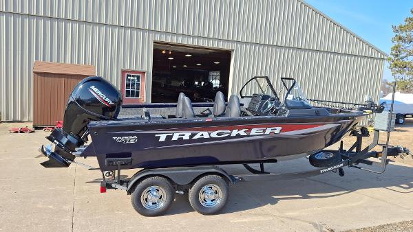 Tracker Targa V-18 WT 2025 Tracker Targa V-18 WT boat on trailer, parked outside a large building.