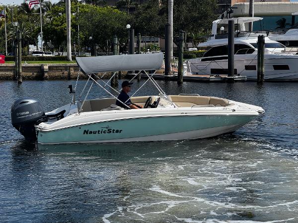 NauticStar 193SC Sport Deck 2022 NauticStar 193SC Sport Deck boat cruising in a marina with a canopy.