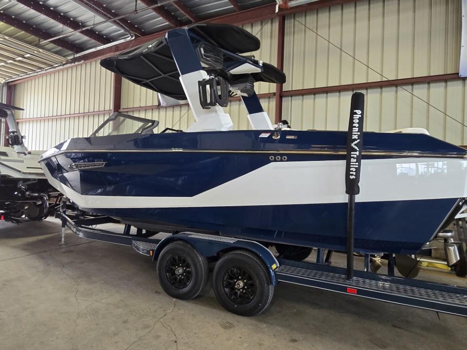 Nautique Super Air Nautique G23 2025 Nautique Super Air Nautique G23 boat on trailer in warehouse setting.