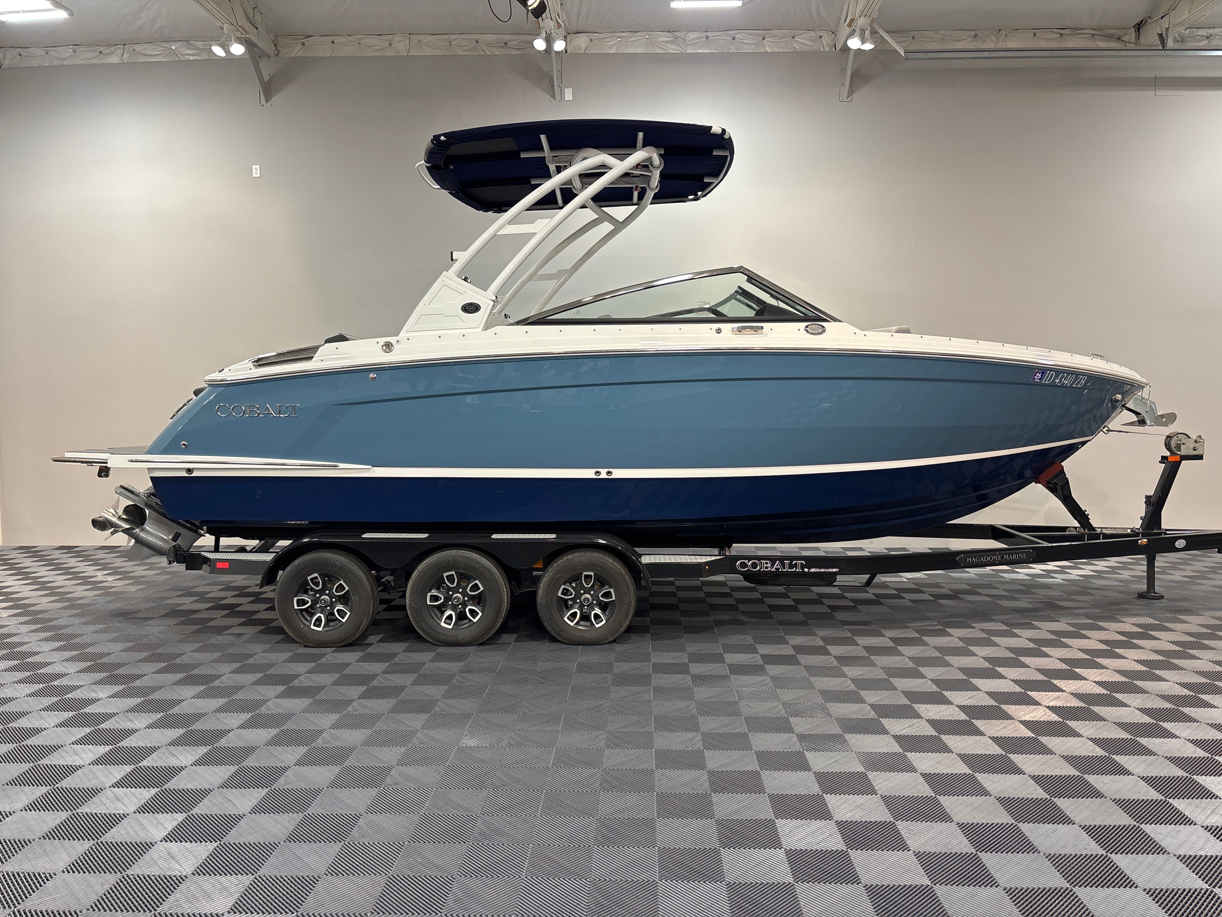 Cobalt R6 2022 Cobalt R6 boat on trailer in showroom, blue and white design.