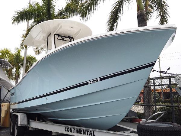 Regulator 23 Center Console 2025 Regulator 23 Center Console boat on trailer, surrounded by palm trees.