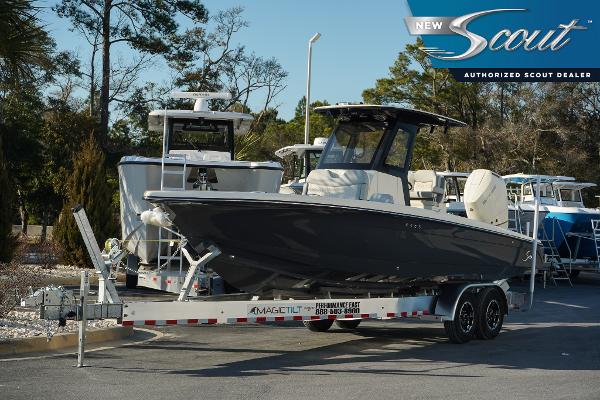 Scout 281 XSS 2025 Scout 281 XSS boat on trailer at authorized dealer, surrounded by trees.