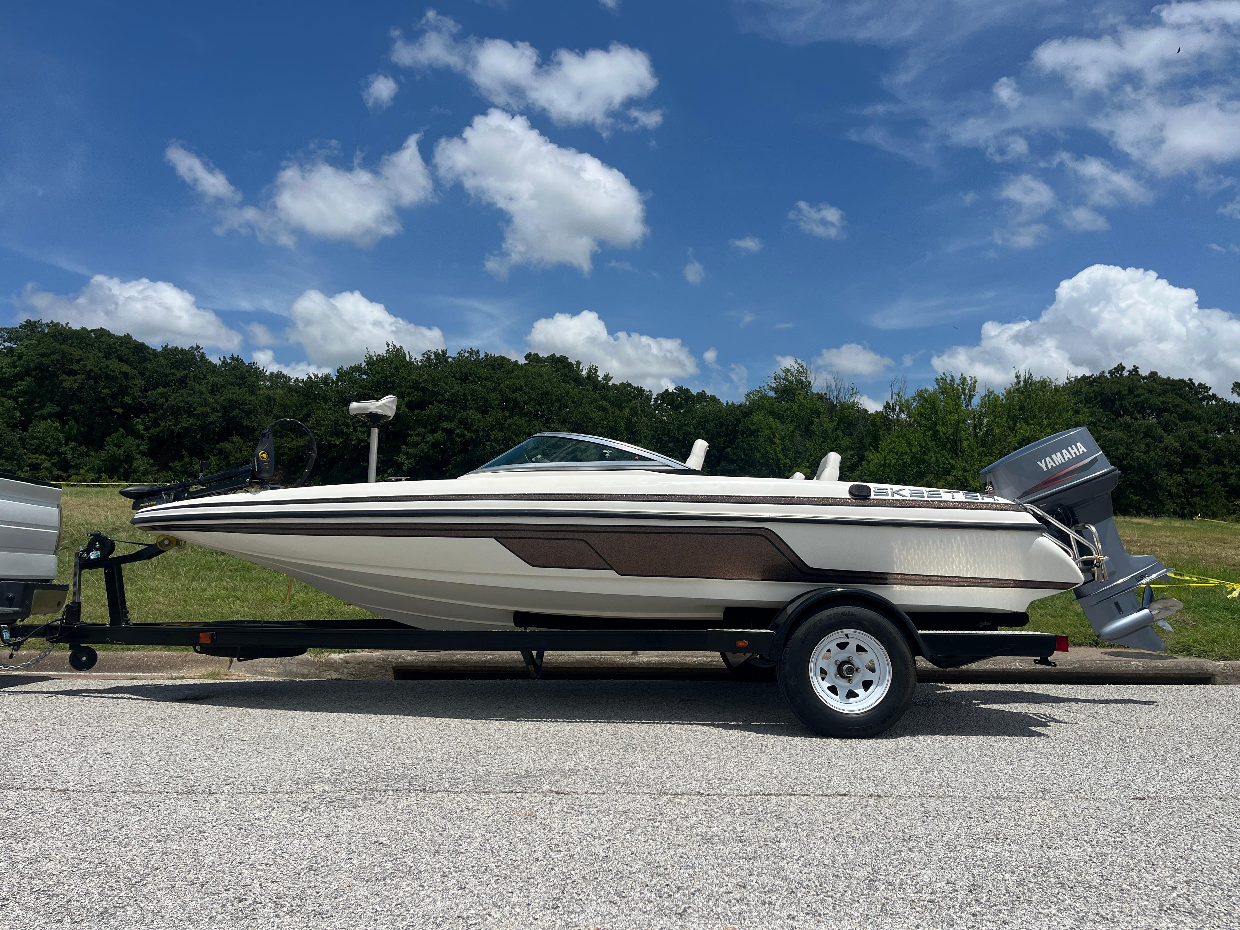 Skeeter 176 SL C 1998 Skeeter 176 SL C boat with Yamaha motor on trailer, parked outdoors.