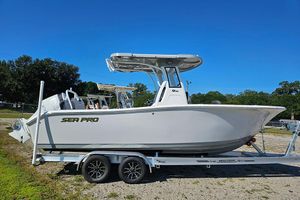 Sea Pro 245FLX Sandbar 2026 Sea Pro 245 Sandbar boat on trailer, parked outdoors under clear blue sky.