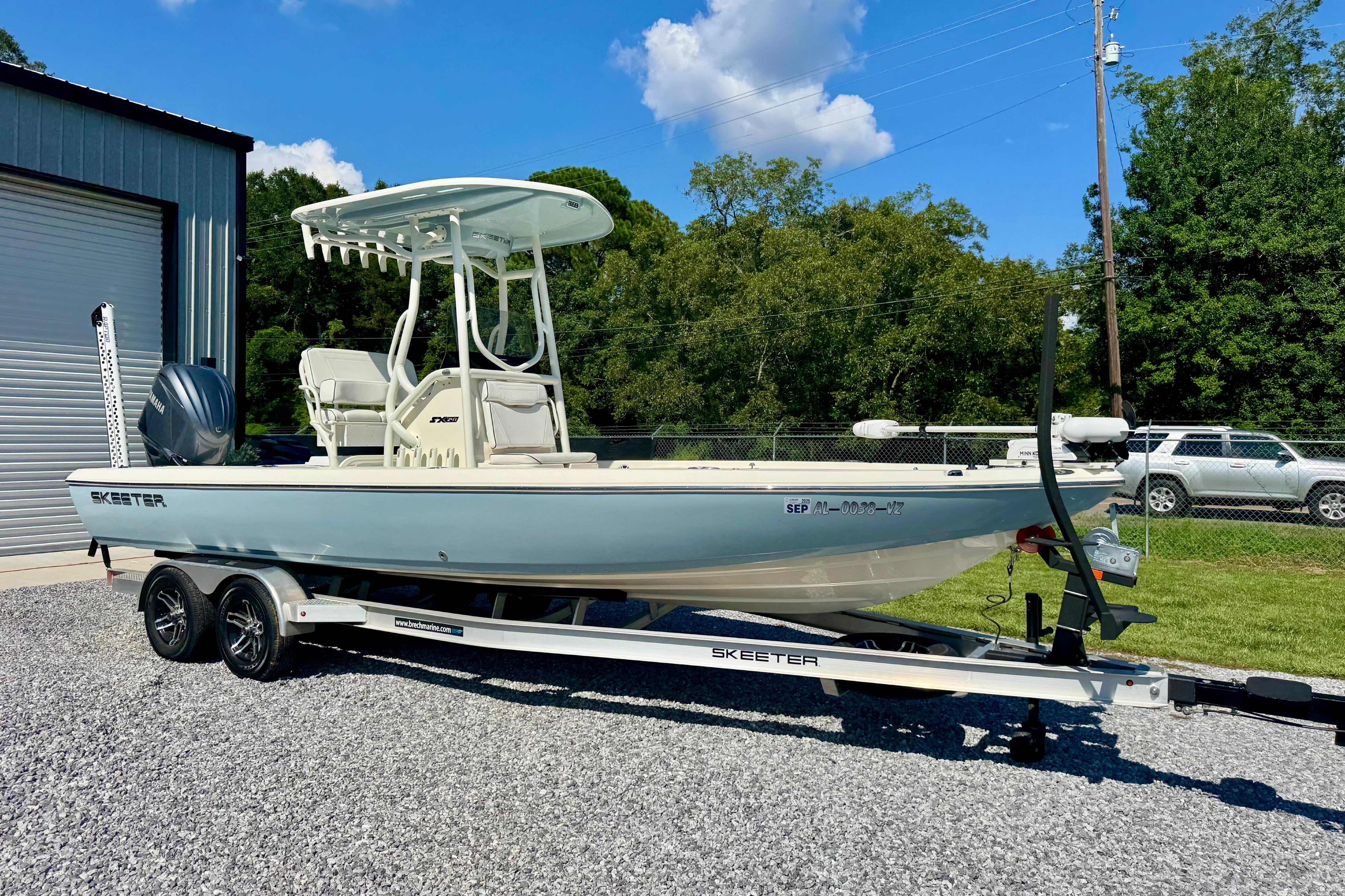 Skeeter SX 241 2024 Skeeter SX 241 boat on trailer, parked outdoors near a garage.