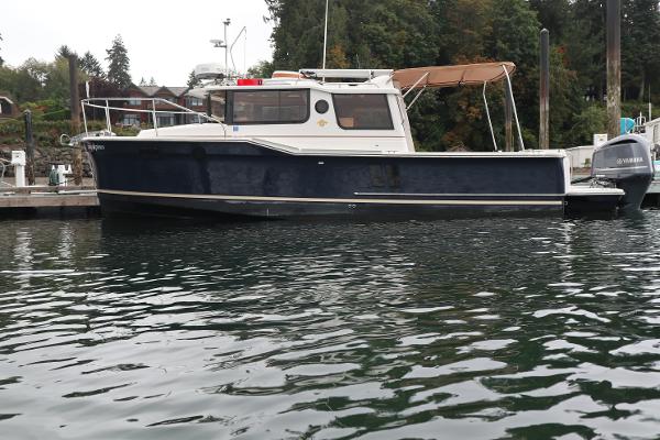 Ranger Tugs R-27 2019 Ranger Tugs R-27 boat docked on calm water.