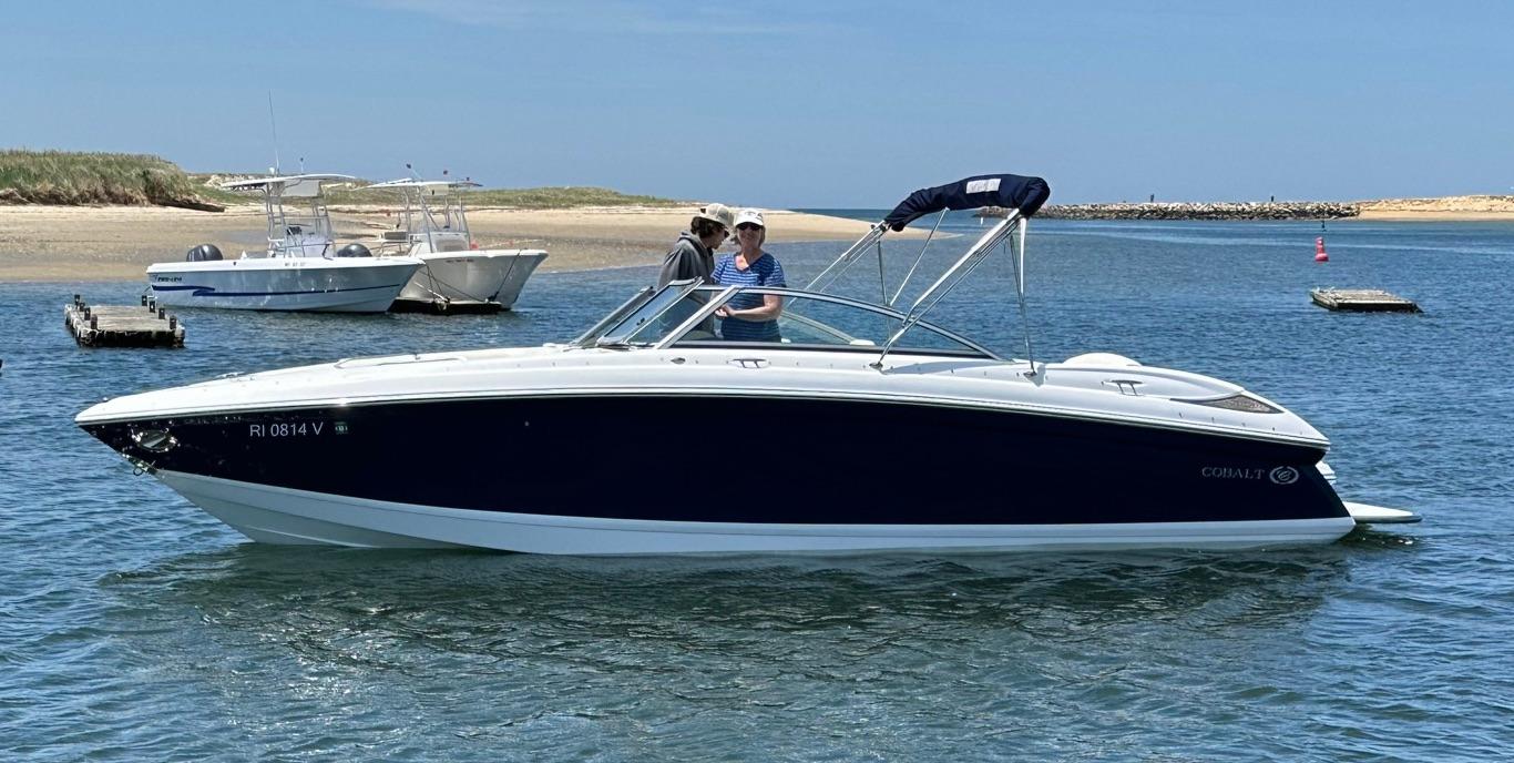 Cobalt 262 2010 Cobalt 262 boat on calm water with two people onboard, clear sky background.