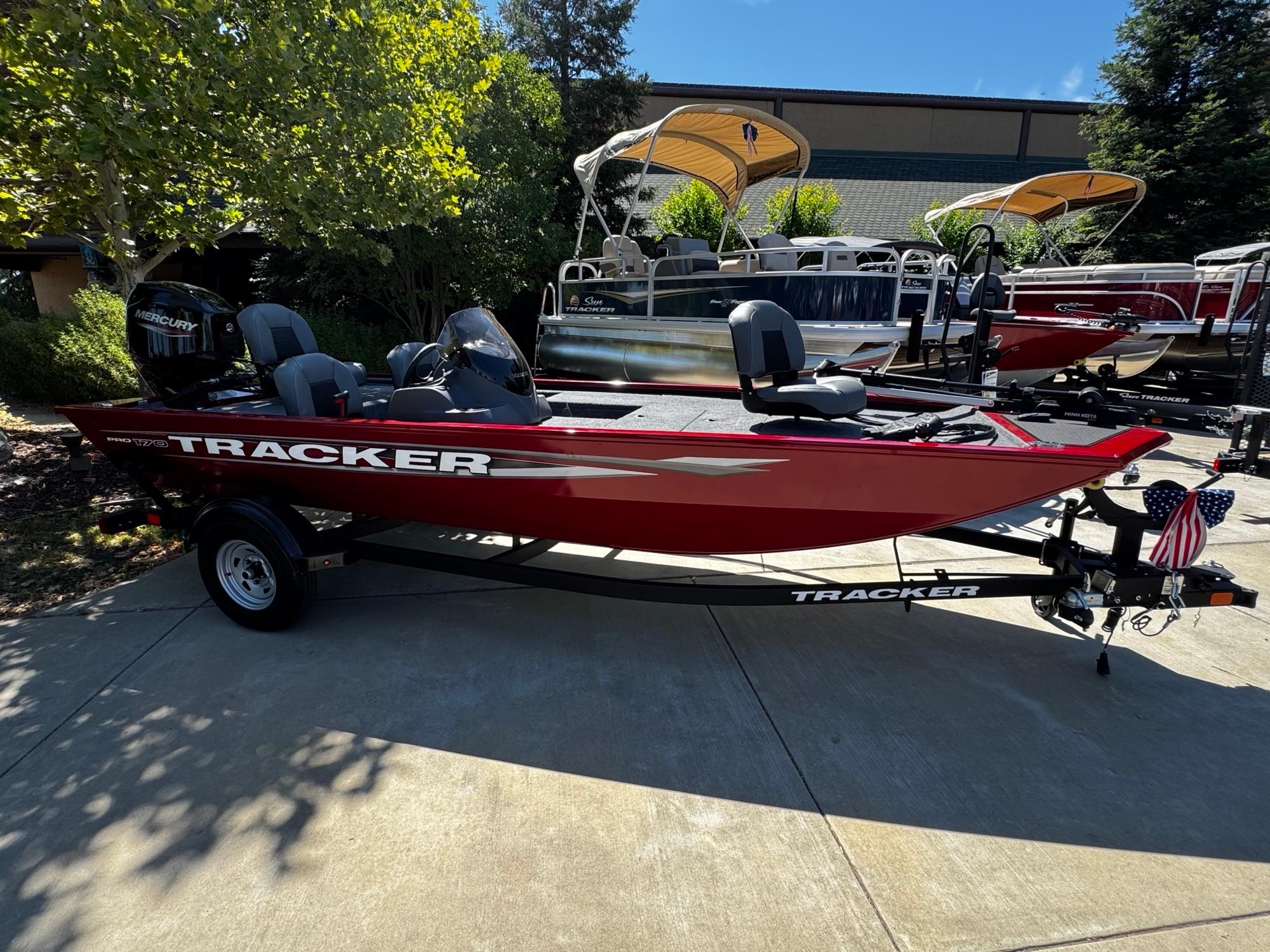Tracker Pro 170 2025 Tracker Pro 170 boat in red, parked outdoors on a sunny day.