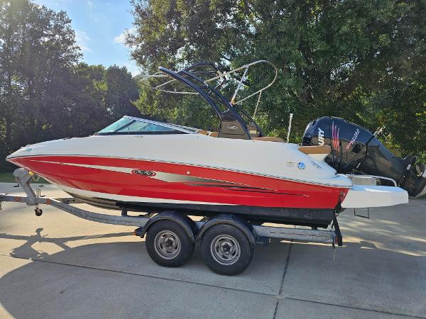 Sea Ray 220 Sundeck Outboard 2014 Sea Ray 220 Sundeck Outboard boat on trailer, red and white design, parked outdoors.