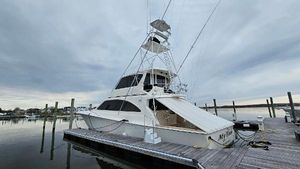 Ocean Yachts 70 Super Sport Ocean Yachts 70 Super Sport 2000 docked at marina under cloudy sky.