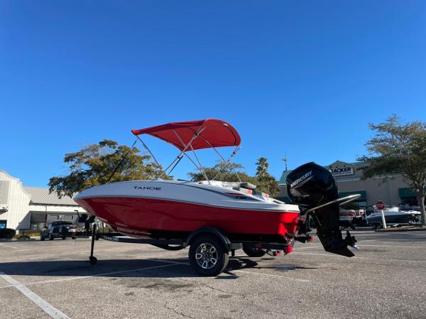 Tahoe T16 2025 Tahoe T16 boat with red canopy and outboard motor in parking lot.