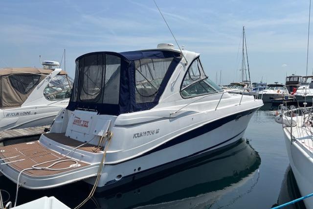 Four Winns 378 Vista 2005 Four Winns 378 Vista yacht docked at marina, featuring sleek design and blue canopy.