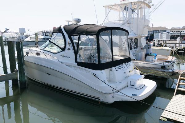 Sea Ray 320 Sundancer 2003 Sea Ray 320 Sundancer docked at marina, featuring sleek design and black canopy.