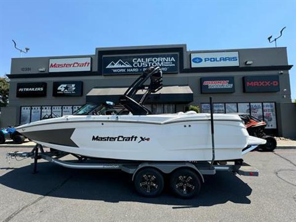 MasterCraft XStar S 2024 MasterCraft XStar S boat on trailer outside dealership.