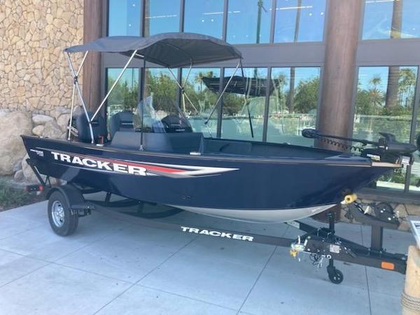 Tracker Pro Guide V-16 SC 2025 Tracker Pro Guide V-16 SC boat on trailer, parked outside a building.