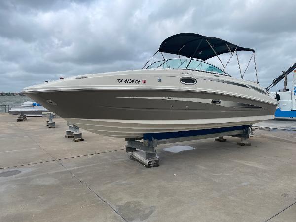 Sea Ray 260 Sundeck 2009 Sea Ray 260 Sundeck boat on dock, overcast sky, blue canopy.