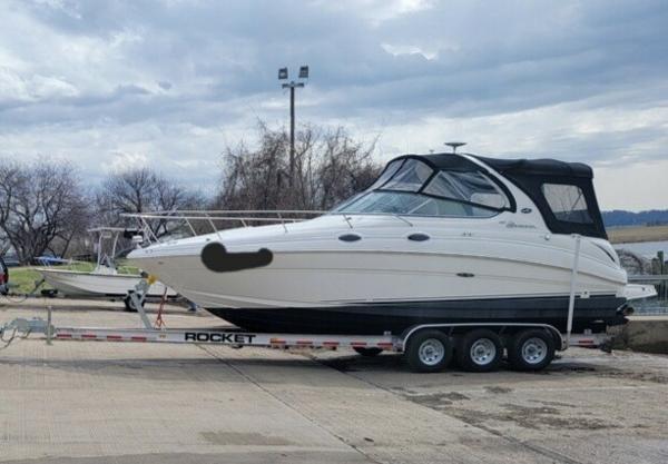 Sea Ray 280 Sundancer 2004 Sea Ray 280 Sundancer on trailer, parked outdoors under cloudy sky.