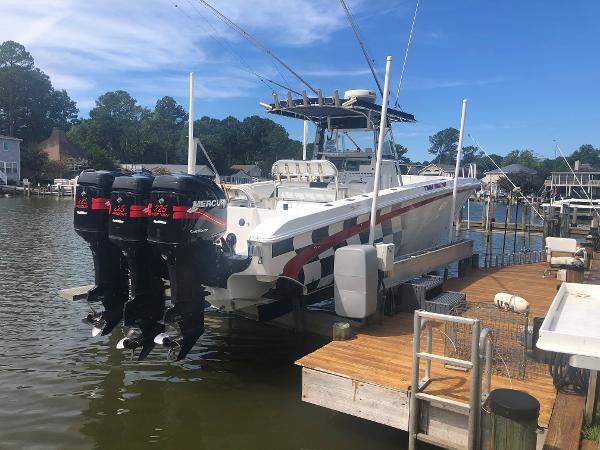 Fountain 38TE 2003 Fountain 38TE boat with triple Mercury outboard engines docked at a marina.