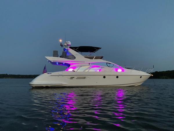 Azimut 50 Flybridge 2005 Azimut 50 Flybridge yacht with vibrant pink lights on calm water.