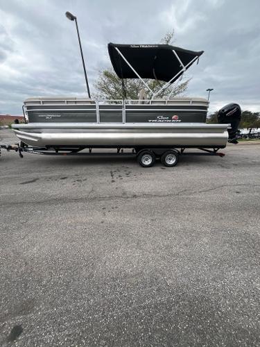 Sun Tracker Party Barge 24 DLX 2024 Sun Tracker Party Barge 24 DLX pontoon boat on trailer, parked outdoors.