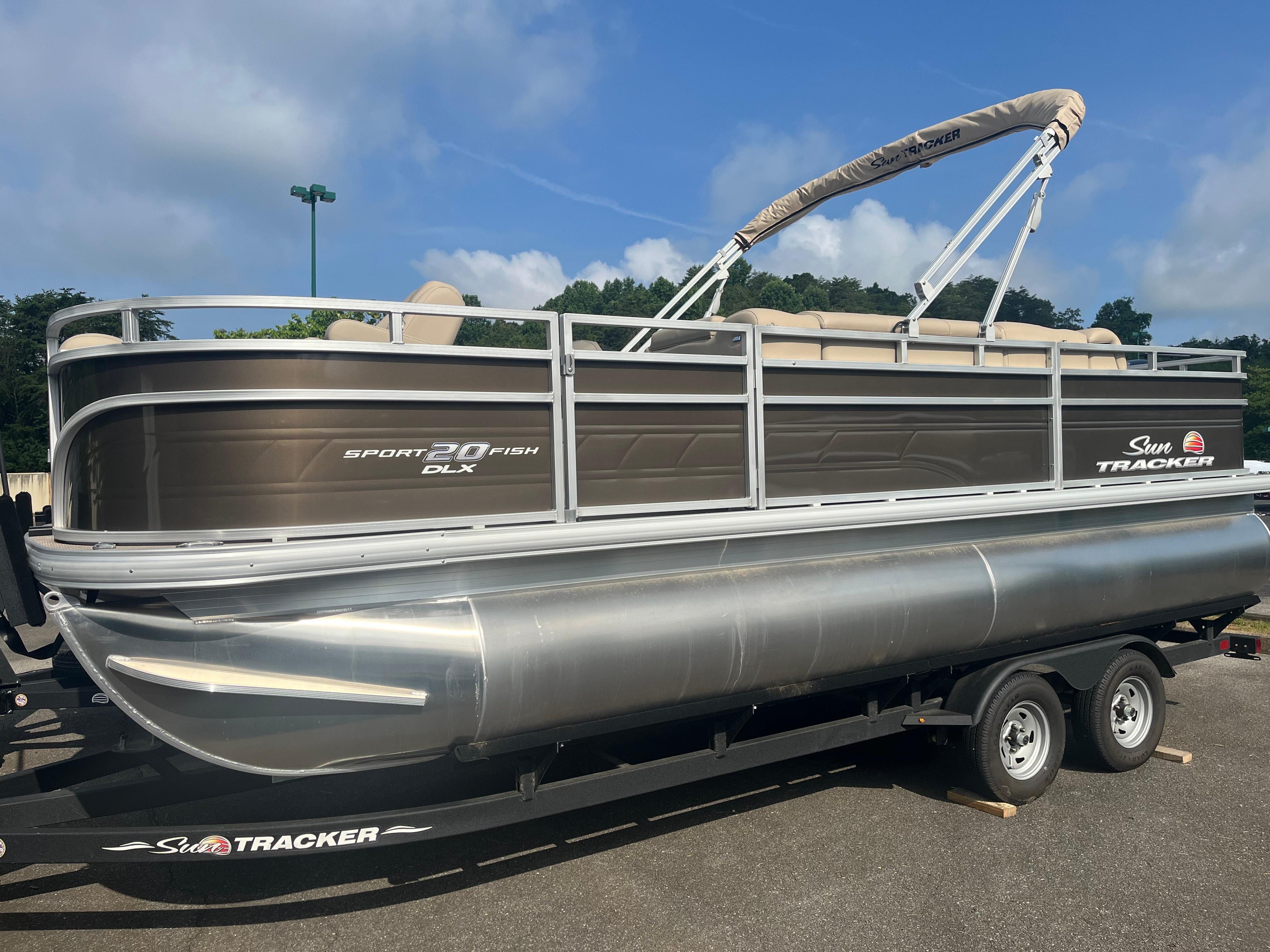 Sun Tracker SportFish 20 DLX 2025 Sun Tracker SportFish 20 DLX pontoon boat on trailer, parked outdoors.