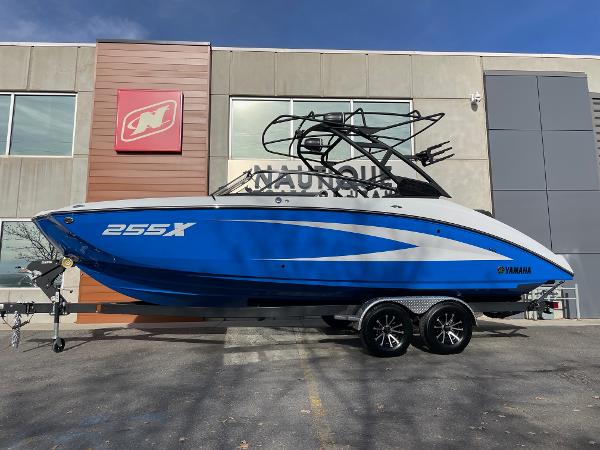 Yamaha Boats 255XD 2025 Yamaha Boats 255XD in blue, parked on a trailer outside a building.