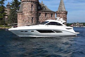 Sea Ray 510 Sundancer 2014 Sea Ray 510 Sundancer yacht cruising near a historic stone castle on a sunny day.