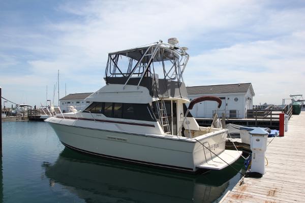 Silverton 34 Convertible 1990 Silverton 34 Convertible boat docked at marina under clear sky.