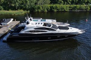 Sunseeker Predator 74 Luxurious 2010 Sunseeker Predator 74 yacht docked on a serene river.