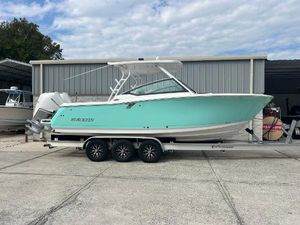 Blackfin 272 DC 2024 Blackfin 272 DC boat on trailer, turquoise hull, parked outside a storage facility.